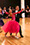 Erik and Rickie dancing the quickstep. Rickie is in a bright pink red dress.